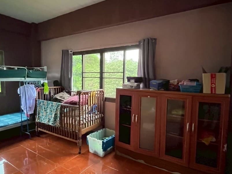 A bedroom at the home, a bunk bed and a wooden crib by the window